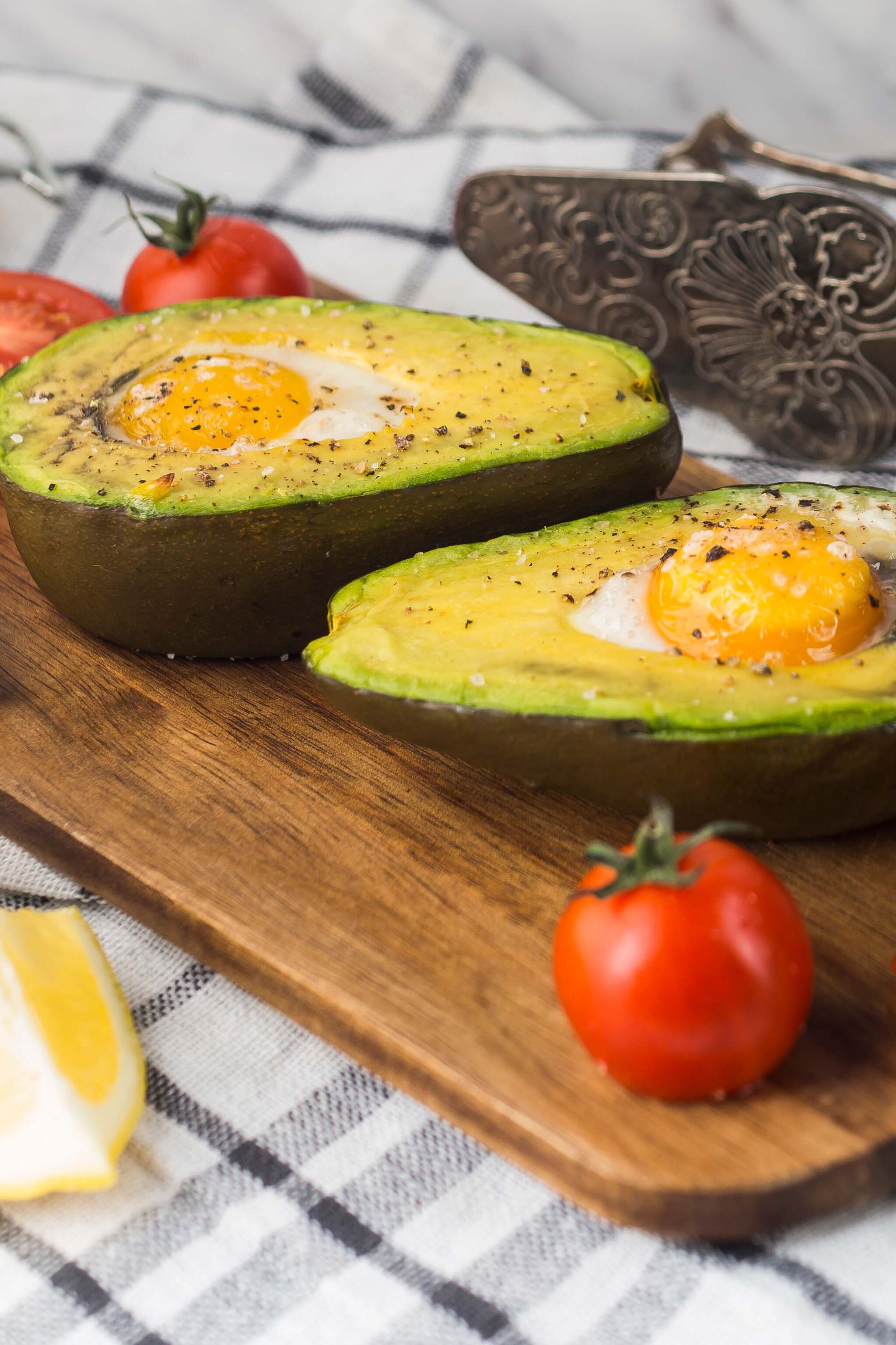 Halved Avocado With Egg York Tomatoes Lemon Slice Chopping Board Napkin With Antique Tong